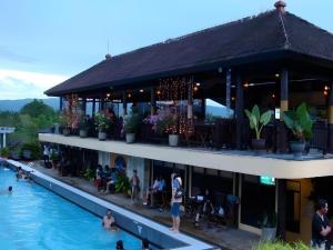 a hotel with people sitting in the swimming pool at Wonua Monapa Hotel Resort in Embeipua