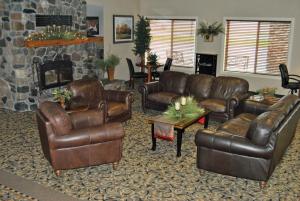 a living room with leather furniture and a fireplace at C'Mon Inn in Thief River Falls