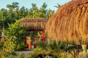 eine Strohhütte mit Strohdach und Bäumen in der Unterkunft Moonlight Resort in Malapascua