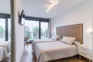 ein Hotelzimmer mit zwei Betten und einem Fenster in der Unterkunft Apto playa Alojamientos Marte in Suances