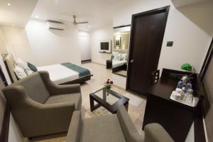 a hotel room with a bed and a living room at Hotel Le Grande - Mumbai International Airport in Mumbai