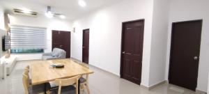 une salle à manger avec une table et des chaises en bois dans l'établissement Spacious 3-Room Home in Miri, à Miri