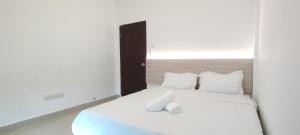 - un lit blanc avec des oreillers blancs dans l'établissement Spacious 3-Room Home in Miri, à Miri