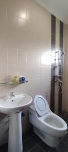 une salle de bain avec des toilettes blanches et un lavabo dans l'établissement Spacious 3-Room Home in Miri, à Miri
