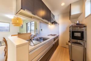 a small kitchen with a sink and a microwave at Jin's Place - 15m to Haneda & Shinagawa in Tokyo