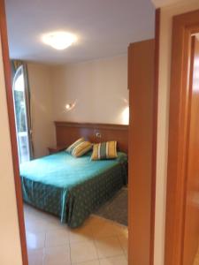 1 dormitorio con 1 cama con sábanas y almohadas azules en Hotel Jean Marie, en Arma di Taggia