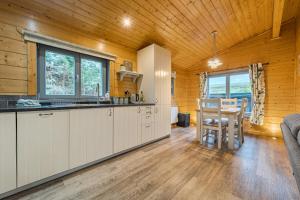- une cuisine et une salle à manger dans une cabane en rondins dans l'établissement Elm Lodge, à Ulverston