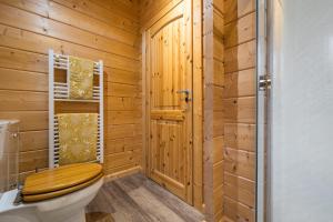 La salle de bains en bois est pourvue de toilettes et d'une fenêtre. dans l'établissement Elm Lodge, à Ulverston 34 autres photos