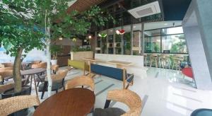 ein Restaurant mit Tischen und Stühlen und Bäumen in der Unterkunft Swansea Resort in Jeju-do