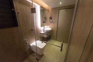 a bathroom with a toilet and a sink and a mirror at Hotel Le Grande - Mumbai International Airport in Mumbai