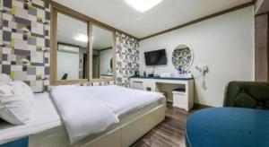 a bedroom with a bed and a desk and a mirror at Dubai Motel in Daejeon