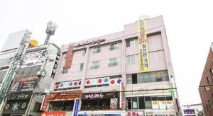 a large building in a city with signs on it at Dubai Motel in Daejeon