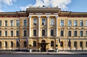 a large yellow building with flags in front of it at Waldorf Astoria Helsinki in Helsinki