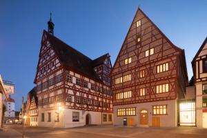a group of buildings in a city at night at Hotel Krone Oettingen in Oettingen in Bayern +45 photos
