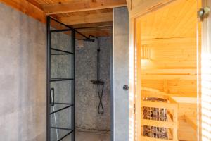a shower in a room with a wooden ceiling at De Friese Wouden in Suameer