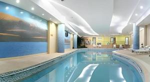 ein Pool in einem Hotel mit einem Gemälde an der Wand in der Unterkunft Dunhuang Grand Soluxe Hotel in Dunhuang