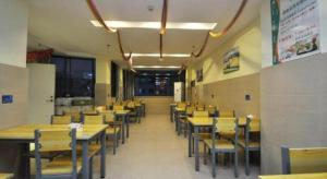 ein Esszimmer mit Holztischen und Stühlen in der Unterkunft GreenTree Inn Xiangshan Transportation Center Bai Hua Road in Xiangshan