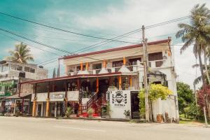 a building on the side of the road with a street at Hummus Hostel Hikkaduwa in Hikkaduwa