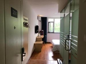 ein Zimmer mit einem Bett und einem Schreibtisch und einem Fenster in der Unterkunft 7 Days Inn Tianjin Ancient Cultural Street Jinshiqiao Metro Station in Tianjin + 233 Fotos