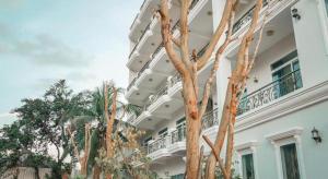 a large white building with trees in front of it at Boutique Kampot Hotel in Kampot