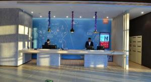 two people sitting at a desk in an office at Ibis Harbin Normal University in Harbin