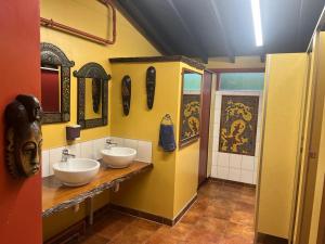 Baño con 2 lavabos y espejos en la pared en Global Village Travellers Lodge, en Greymouth 43 fotos más