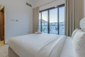 富查伊拉Grand 4BR Villa with Majestic Mountain and Sea Views, Assistant Room, and Private Pool, Just a Few Minutes Drive from Fujairah Finest Beaches and Camping Sites, Al Dana Island, Fujairah by Deluxe Holiday Homes的房间里有一张白色的大床，窗户很大 更多48张照片