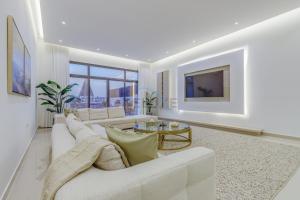 富查伊拉Grand 4BR Villa with Majestic Mountain and Sea Views, Assistant Room, and Private Pool, Just a Few Minutes Drive from Fujairah Finest Beaches and Camping Sites, Al Dana Island, Fujairah by Deluxe Holiday Homes的带沙发和电视的白色客厅