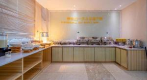 eine Küche mit einer Theke mit vielen Töpfen und Pfannen in der Unterkunft City Comfort Inn Zhanjiang Shimao Building Chikan Old Street in Tchia-k'am