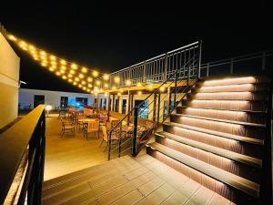 a deck with a table and chairs and lights at Hi Ocean Gyeongpo in Gangneung