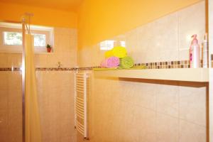 La salle de bains est pourvue d'une douche et d'une étagère avec des serviettes. dans l'établissement Jázmin Apartman, à Szeged