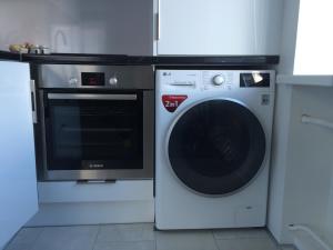 a washing machine and a microwave in a kitchen at Valentine's White Lux in Kuldīga
