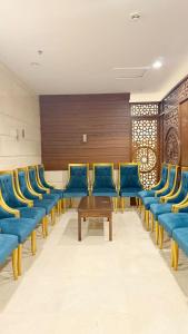 Una sala de espera con sillas azules y una mesa. en رتاج إن, en Al Khansāk
