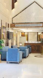 eine große Lobby mit blauen Stühlen und einem Tisch in der Unterkunft رتاج إن in Al Khansāk + 7 Fotos