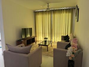 un salon avec deux canapés et une télévision dans l'établissement Seaside Escape Ocean Views Uswetakeiyawa, à Uswetakeiyawa