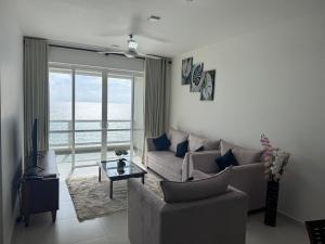 Una sala de estar con un sofá y vista al mar. en Seaside Escape Ocean Views Uswetakeiyawa, en Uswetakeiyawa