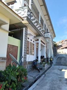 a building with two motorcycles parked outside of it at Manggala Homestay Bromo in Ngadisari
