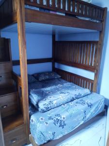 a wooden bunk bed with a blue and white bedspread at Manggala Homestay Bromo in Ngadisari +6 photos