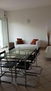 リーヴァ・デル・ガルダにあるApartment Negrelliのガラスのテーブル(椅子付)、ソファが備わります。