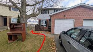 Ein Auto parkte vor einem Haus mit einem roten Schlauch in der Unterkunft Cozy Bachelor Apartment at Trillium in Kingston