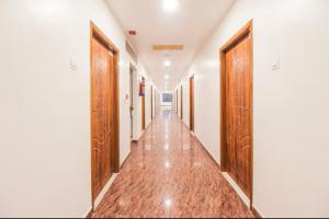 an empty corridor with wooden doors in a building at Sakthi Grand in Erode