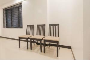 four chairs sitting in a row in a room at Sakthi Grand in Erode