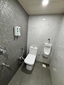 a bathroom with a toilet and a urinal on the wall at The Brij Retreat , 50 mtr from Shri Krishna Janambhumi in Mathura