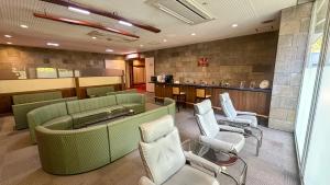 Livemax Resort Hida Takayama Garyu no Sato في تاكاياما: غرفة انتظار مع كراسي خضراء وبار