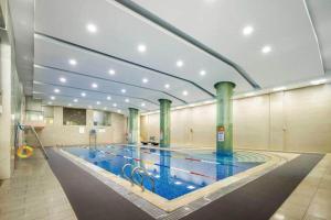 ein großes Schwimmbad in einem großen Gebäude in der Unterkunft New Century Hotel Nanjing in Pukou