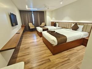 a hotel room with two beds and a tv at Ricch Hotels in Hyderabad +9 photos