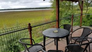 a table and chairs on a porch with a view of a field at Apartamenty Prima in Dziwnówek
