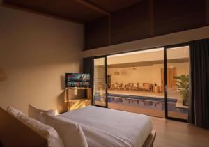 金巴兰Kinama Villa的一间带大床的卧室和一个游泳池