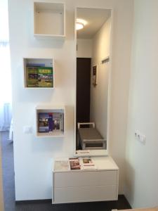 una habitación con espejo y una mesa con libros. en Valentine's White Lux, en Kuldīga