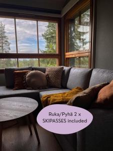 a living room with a couch with pillows and a table at Rinneköngäs - Ruka-Pyhä 2x SKIPASS included in Ruka